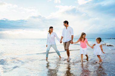 mutlu aile eğlenceli gün batımında sahilde yürüyüş
