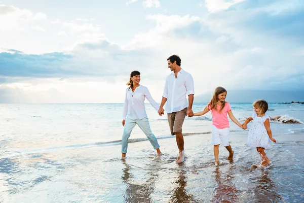 Gelukkige familie veel plezier wandelen op het strand bij zonsondergang — Stockfoto