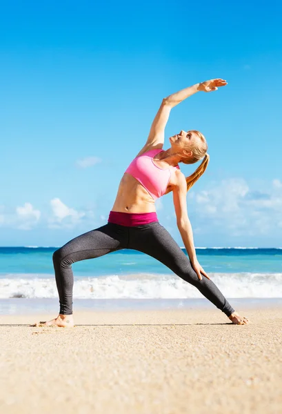 Frau dehnt sich am Strand — Stockfoto