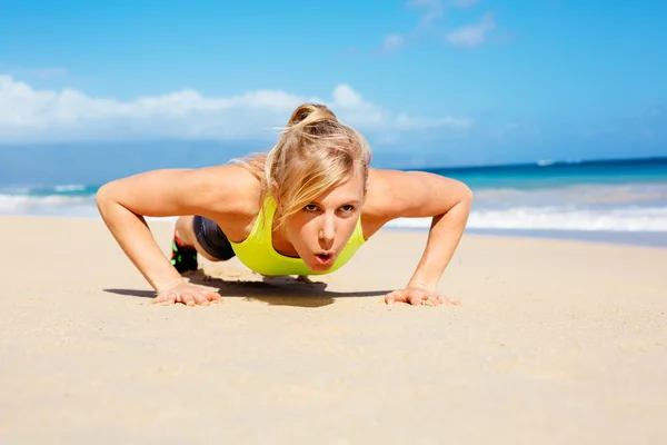 Atraktivní žena, která dělá push up mimo. — Stock fotografie