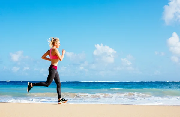 Frau läuft am Strand — Stockfoto