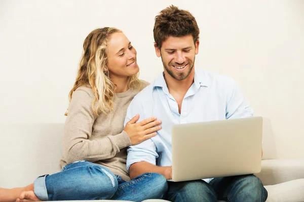 Casal jovem em casa usando laptop — Fotografia de Stock