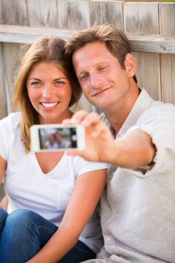 Çift telefonuyla selfie çekiyor.