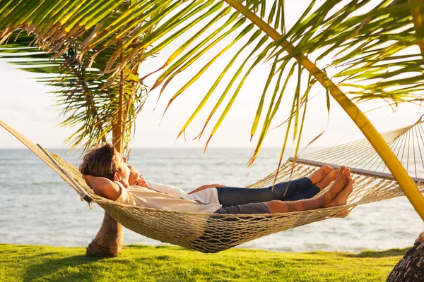 Casal relaxante em rede tropical — Fotografia de Stock