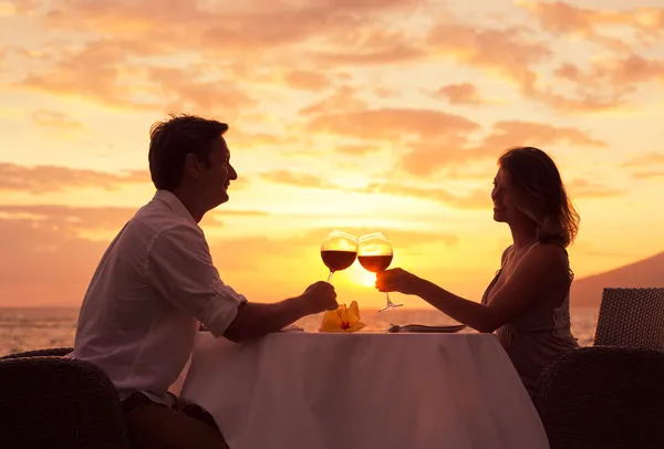 Pareja disfrutando de una cena romántica al atardecer — Foto de Stock