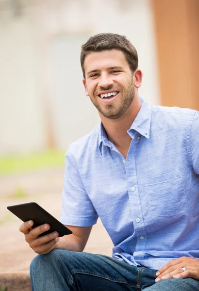 Young man reading E-book outside — Stock Photo, Image