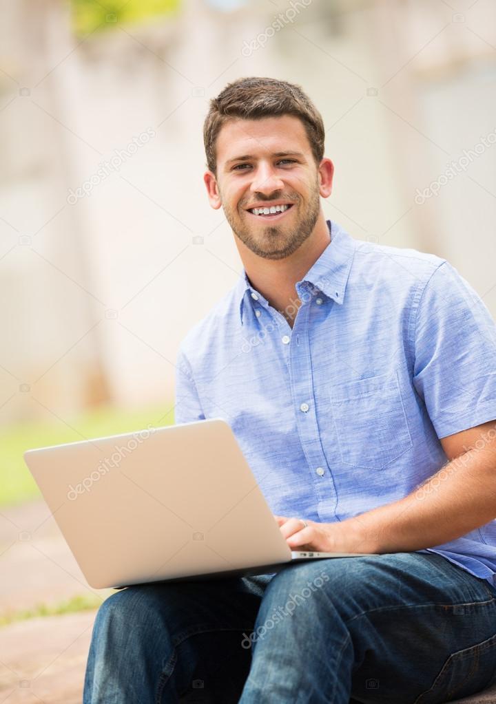 Young man working outside on laptop