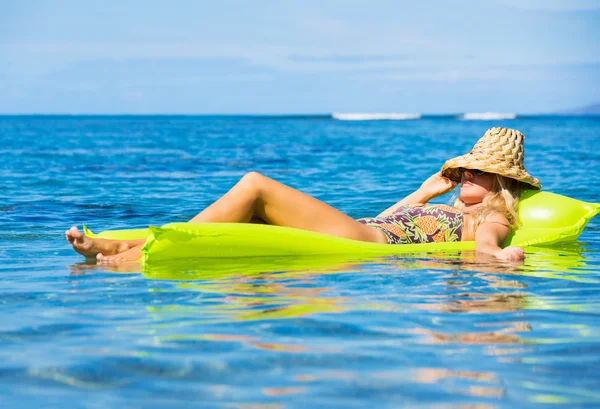 Junge Frau schwimmt auf Floß — Stockfoto