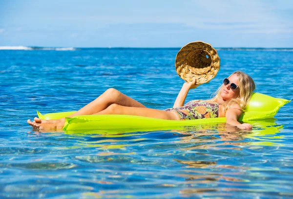 Junge Frau schwimmt auf Floß — Stockfoto