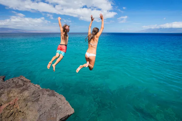 Amigos acantilado saltando en el océano — Foto de Stock