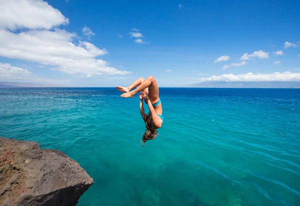 Woman doing backflip into ocean — Stock Photo, Image