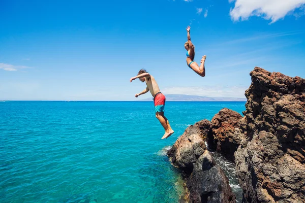 Amigos acantilado saltando en el océano — Foto de Stock