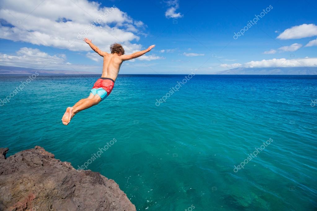 Hombre saltando desde el acantilado en el océano 2023