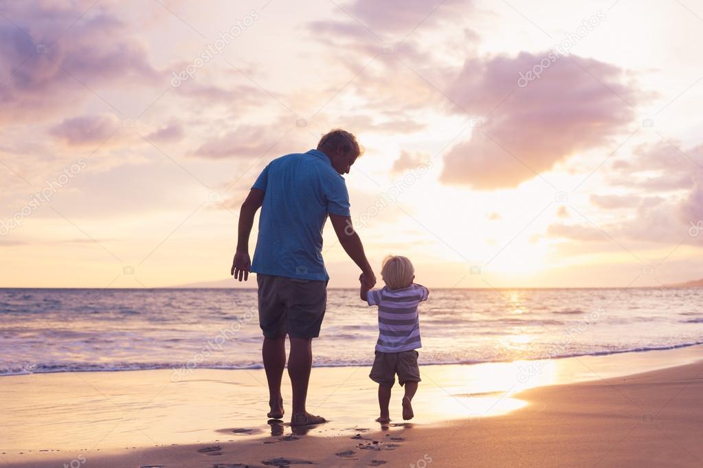 Father and son wallking on the beach