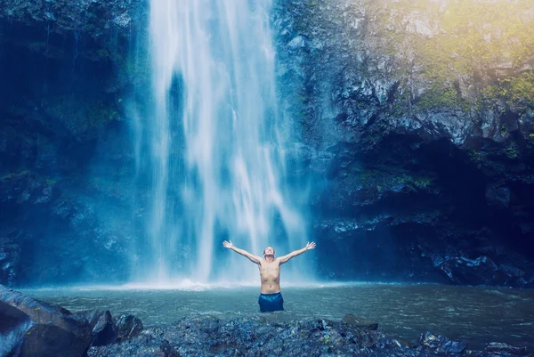 Mann im Pool am Fuße des großen Wasserfalls — Stockfoto