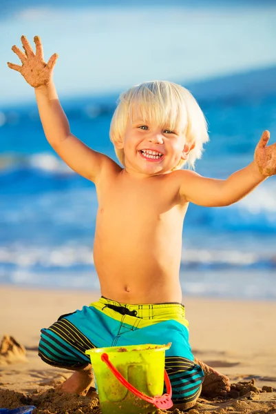 Ung pojke leker på stranden — Stockfoto