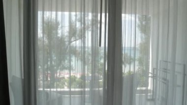 White curtain of the bedroom in hotel resort vacation balcony with background of the sea of Phuket