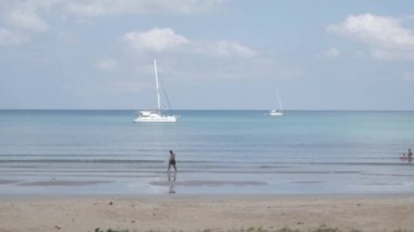 December 28,2021: Phuket,Thailand: people relaxing on the white sand beach with wave from peaceful sea in sunshine daytime