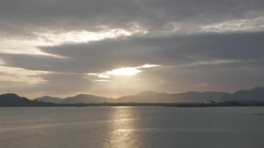 Yazın, Phuket Adası 'nın deniz kıyısındaki sıradağların üzerinden gün batımının güzel manzarası