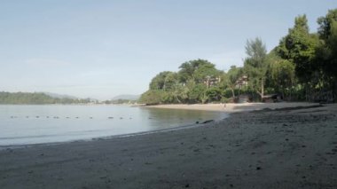 Beyaz kumlu sahil ve gün ışığında huzurlu denizden el sallamak.