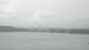 Phuket town from aerial view while raining from the sea bay. Tropical weather