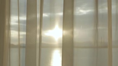 Sahildeki balkon tatil köyünden dağ sıraları ve deniz üzerinde gün batımı manzarası. Seyahat yerleri. Yaz tatili