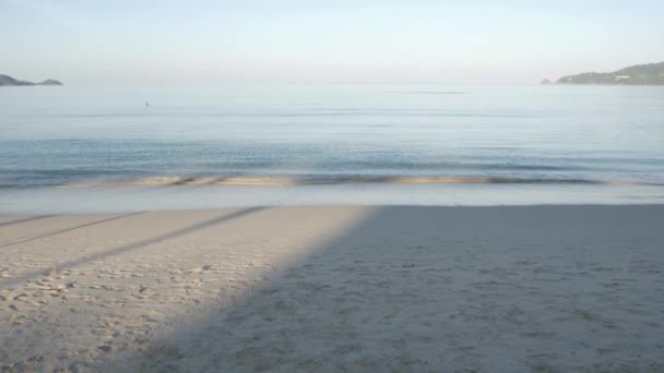 해변에 모래와 파도가 여름철 햇살이 내리쬐는 펼쳐져 — 비디오