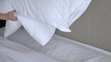 Otel servisi konsepti, temizlikçi, yastığı beyaz çarşafla yatır, sabah yatağı topla.