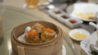 Lokantada Çin Dim Sum buğulaması yemek için çubuk kullanmak. Çin lokantasında ünlü suimai.