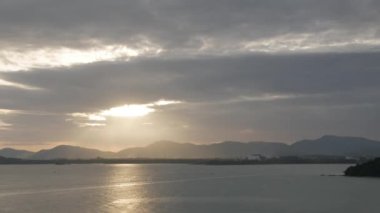 Yazın, Phuket Adası 'nın deniz kıyısındaki sıradağların üzerinden gün batımının güzel manzarası