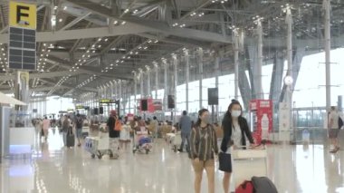 23 Mart 2022: Bangkok, Tayland: POV havaalanının kalkış terminali Suvannabhumi Havalimanı 'nda çok sayıda yolcu yürürken covid salgını