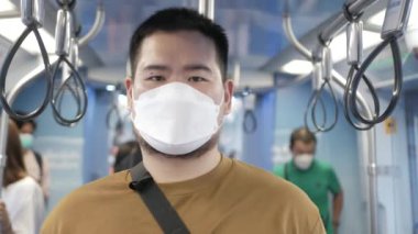 asian man using smartphone while in public subway transportation