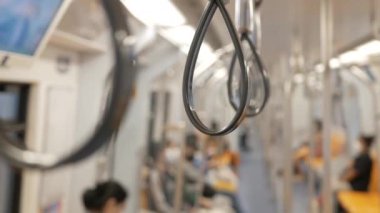 Metro, toplu metro taşımacılığı treninde tırabzan ya da kayışları tutan ellere yakın çekim.