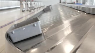 Havaalanı bagaj bandı görüntüsü. Bagaj teslim kemerindeki bagaj. İnsanlar uçaktan gelir, bekler, çantalarını ve çantalarını toplarlar.