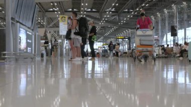 23 Mart 2022: Bangkok, Tayland: POV havaalanının kalkış terminali Suvannabhumi Havalimanı 'nda çok sayıda yolcu yürürken covid salgını
