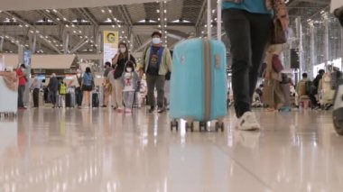 23 Mart 2022: Bangkok, Tayland: POV havaalanının kalkış terminali Suvannabhumi Havalimanı 'nda çok sayıda yolcu yürürken covid salgını
