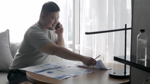 Asian Man Answering Telephone Mobile Phone While Working Desk — Vídeo de Stock