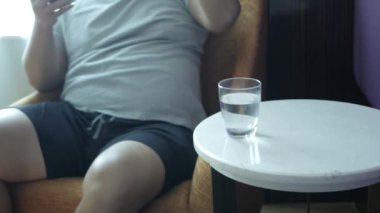 Otelin oturma odasında dinlenirken bir bardak su içmek için manzaraya bak.