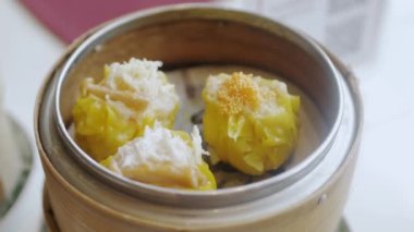 Lokantada Çin Dim Sum buğulaması yemek için çubuk kullanmak. Çin lokantasında ünlü suimai.