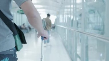 Gezgin 'in eli havaalanında bir bavul taşırken tatile çıkıyor.