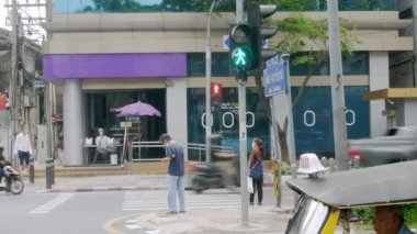 26 Mart 2022: Bangkok, Tayland: Silom Yolu kavşağındaki Tayland Havayolu ofisinin önünde insanlar karşıya geçmek için beklerken