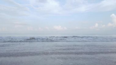 Kumlu beyaz plajda köpüklü doğal deniz dalgası suyu, yaz sahili deniz manzarası.