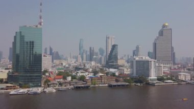 22 Mart 2022: Bangkok, Tayland: Bangkok 'ta nehir kıyısındaki Bangkok higrise binası ile Chao the River' ın yavaş çekim manzarası