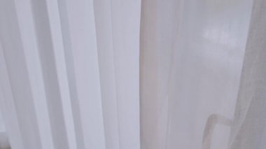 POV, otel odasında dinlenirken adamın elini tutup beyaz perdeyi açar.