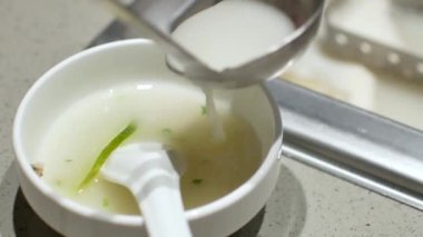 Kasenin içine et suyu koyarken 4k video görüntüsü.