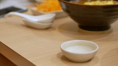 4k video soya sosunu küçük sos tabağına dökerken odaklanıyor