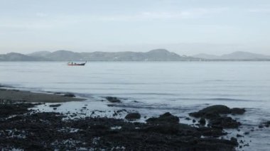Beyaz kumlu sahil ve gün ışığında huzurlu denizden el sallamak.
