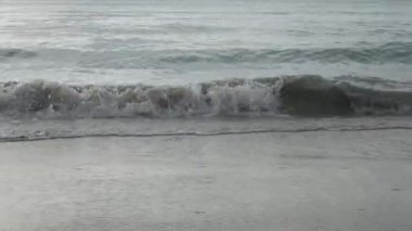 Dalganın yüzey dokusu, yaz güneşinde, beyaz kumsaldaki sakin denizden geliyor. Yaz tatili doğası