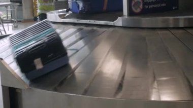 Bagaj teslim kemeri üzerinde hareket ederken birçok valizin görüntüsü