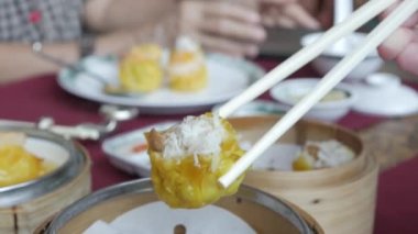 Lokantada Çin Dim Sum buğulaması yemek için çubuk kullanmak. Çin lokantasında ünlü suimai.